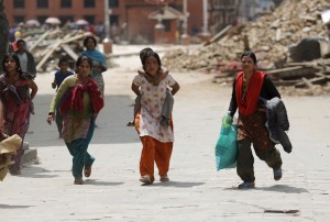 People rush for safety during a strong aftershock after an earthquake, in Kathmandu