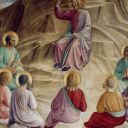 Cristo parla con i suoi discepoli che sono seduti in cerchio intorno a lui sulle rocce. I discepoli sono di spalle.