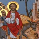 Un uomo vestito di bianco e rosso con un cerchio d'oro intorno alla testa cavalca un mulo. Dietro ci sono altri uomini con cerchi dorati intorno alla testa. Davanti ci sono delle persone che si inginocchiano