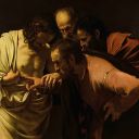 Sulla sinistra c'è un uomo illuminato dalla luce e con un vestitobianco. Ha una ferita sul petto. Un uomo davanti a lui mette il dito nella ferita. Dietro di loro ci sono altri due uomini.