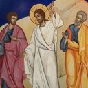 Tre uomini camminano per strada. Quello a sinistra ha un mantello rosa. Quello al centro è vestito di bianco. Quello a destra ha una tunica gialla. Dietro c'è una roccia gialla.