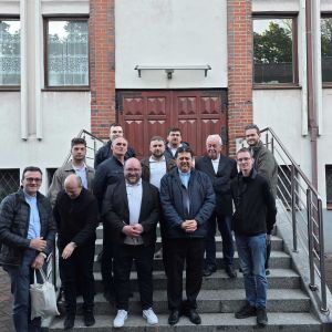 Gruppo di uomini di diverse età su una scala di un protone. Tra loro c'è anche padre Pedro Tramontin, superiore generale dei camilliani