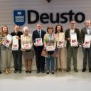 dodici persone, uomini e donne, mostrano la trga bianca di un premio che hanno ricevuto. Dietro di loro c'è il logo dell'università di Desto che si trova a Bilbao, in Spagna