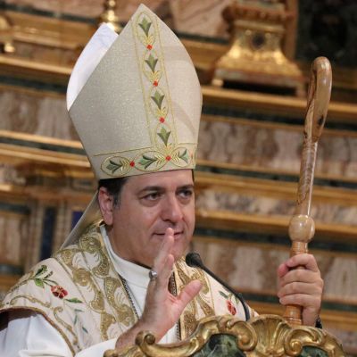 Un vescovo vestito di bianco con il cappello a punta celebra la messa per la festa della Maddalena.
