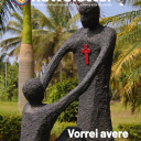 In un parco ci sono due statue in pietra: una statua è in piedi e ha una croce rossa sul petto. L'altra statua è seduta per terra. La statua in piedi sta alzando per le mani la statua seduta per terra.