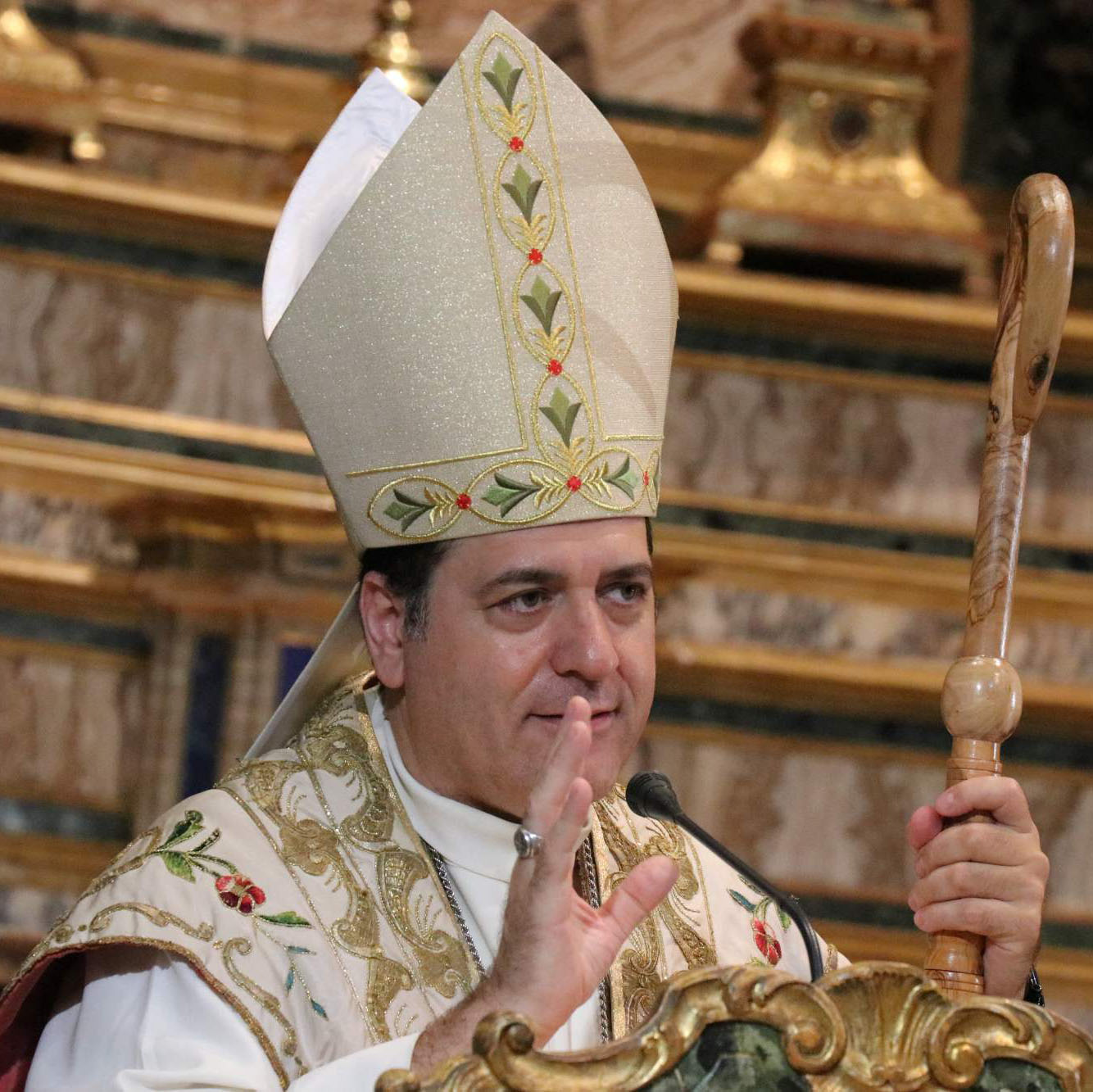 Un vescovo vestito di bianco con il cappello a punta celebra la messa per la festa della Maddalena.