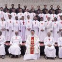 gruppo di uomini vestiti con aniti sacerdotali bianchi con la croce rossa di san Camillo