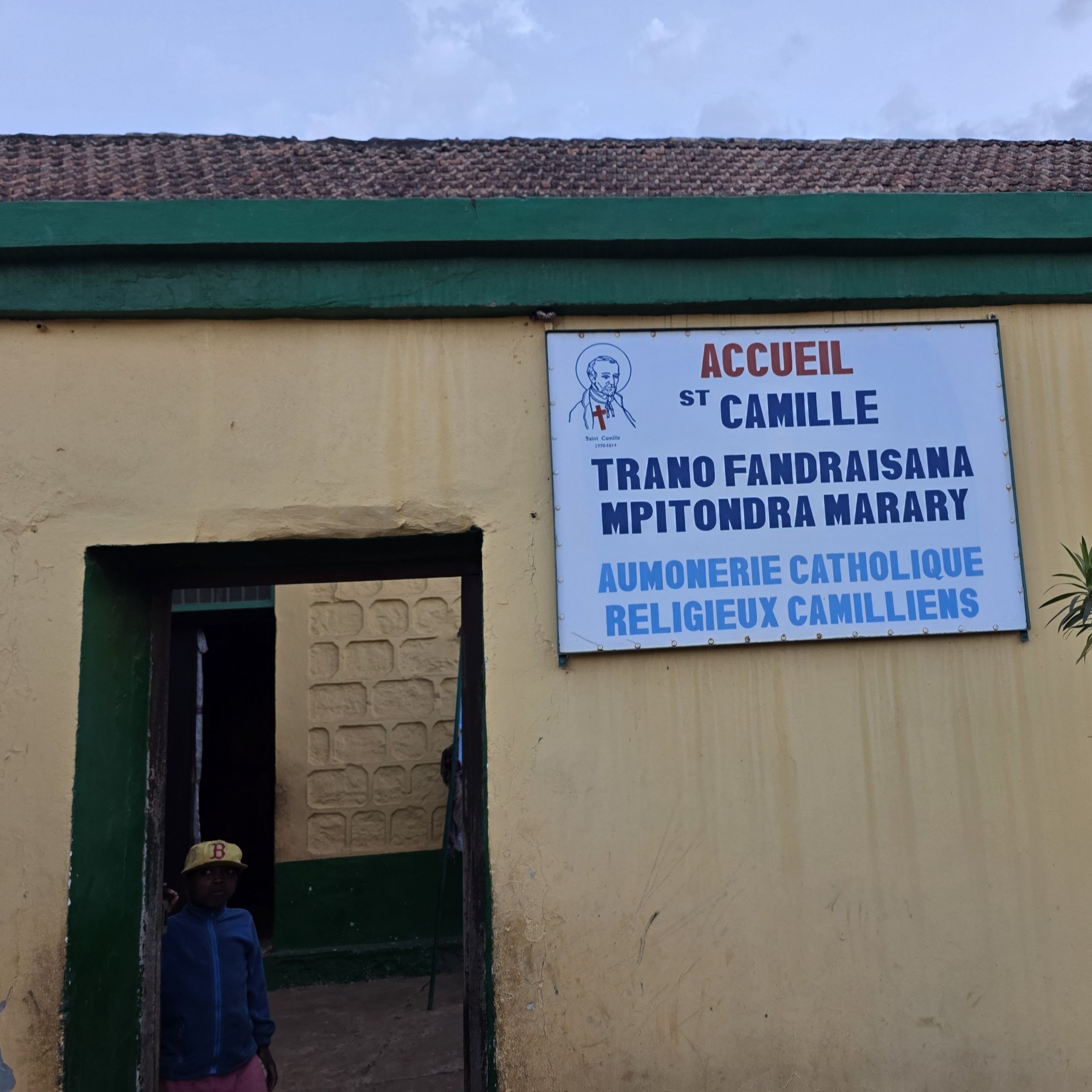 Nella foto c'è una l'ingresso di una struttura sanitaria costrutita dai camilliani in Madagascar. I muri sono gialli.